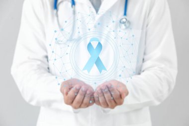 Doctor and blue ribbon on virtual screen against light background. Prostate cancer awareness concept