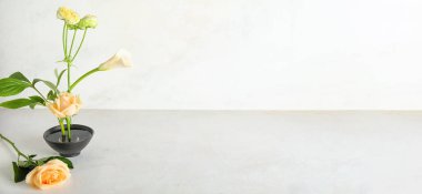 Beautiful ikebana on light background with space for text