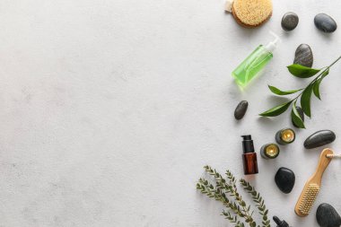 Composition with bath supplies, burning candles and spa stones on light background
