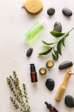 Composition with bath supplies, burning candles and spa stones on light background
