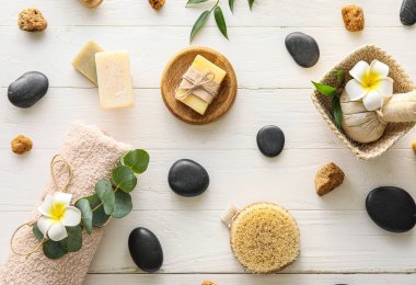 Beautiful spa composition with tropical flowers on light wooden background