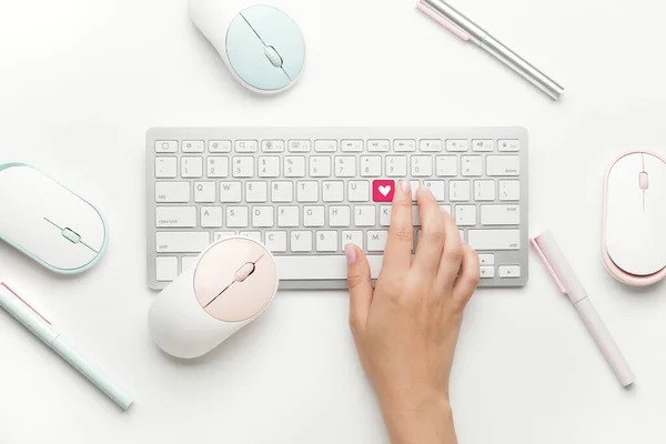 Female hand with keyboard and mouse devices on white background, top view. Online dating concept