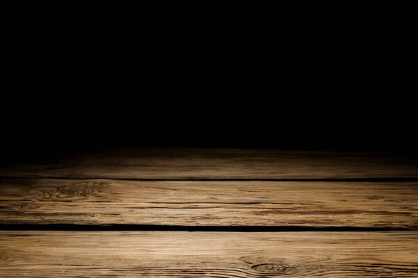 Wooden table top on black background