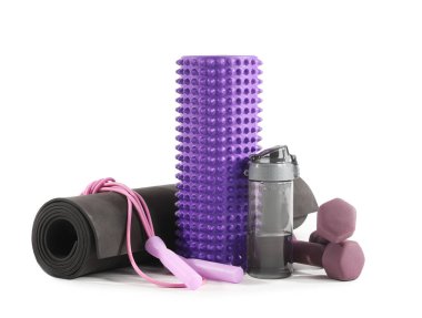 Foam roller, bottle of water, mat, skipping rope and dumbbells on white background