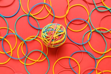 Colorful rubber band ball on red background