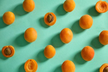 Composition with ripe apricots on color background