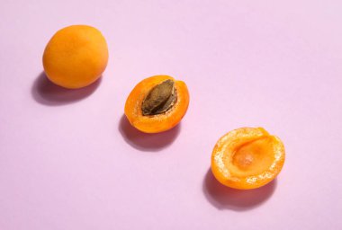 Tasty apricots on pink background