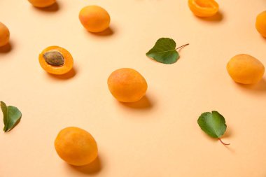 Many ripe apricots on color background