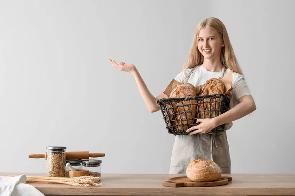 Νεαρή Γυναίκα Κρατά Καλάθι Καρβέλια Φρέσκο Ψωμί Και Δείχνει Κάτι — Φωτογραφία Αρχείου