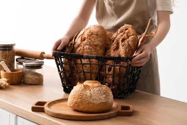 Young Woman Holding Basket Loaves Fresh Bread Light Background — Stock Photo, Image