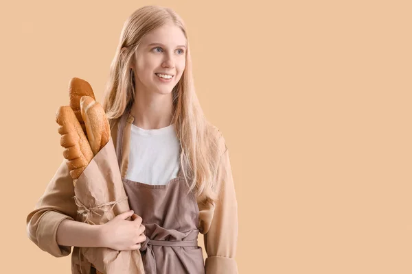 Young Woman Holding Parchment Paper Fresh Bread Beige Background — Stock Photo, Image