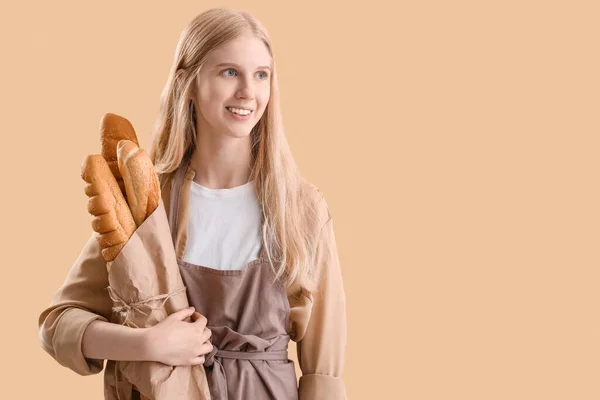 Young Woman Holding Parchment Paper Fresh Bread Beige Background — Zdjęcie stockowe