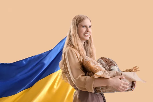 Young Woman Holding Basket Fresh Bread Flag Ukraine Beige Background — Stockfoto