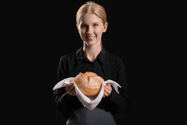 Νεαρή Γυναίκα Κρατώντας Χαρτοπετσέτα Φρέσκο Ψωμί Μαύρο Φόντο — Φωτογραφία Αρχείου