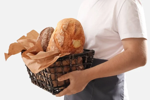 Man Holding Basket Loaves Fresh Bread Parchment Paper Light Background — Zdjęcie stockowe