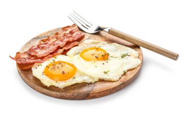 Wooden plate of tasty fried eggs with bacon on white background