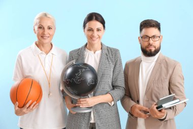 Teachers with ball, globe and books on blue background