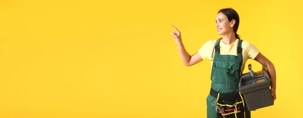 Female Worker Tools Bag Pointing Something Yellow Background Space Text — Photo