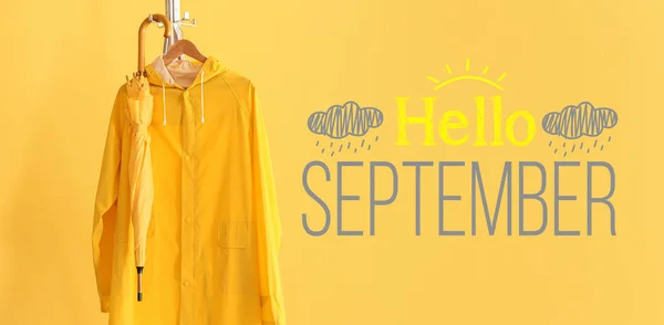 Text Hello September Rack Raincoat Umbrella Yellow Background — Zdjęcie stockowe