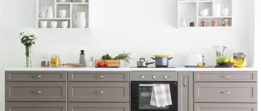 Stylish interior of modern kitchen with electric stove and cookware