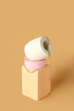 Composition with showcase pedestal and necklace on beige background