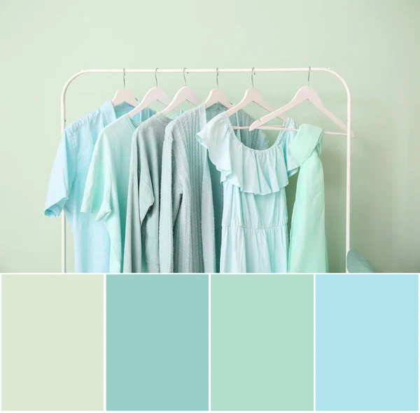 Rack with blue clothes on mint background. Different color patterns