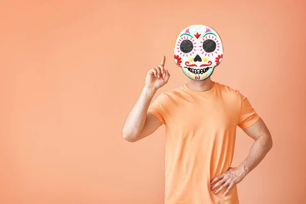 Man with scary cookie instead of his head on beige background. Halloween celebration