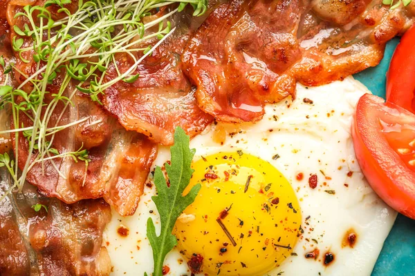 Tasty fried egg with bacon and spices, closeup