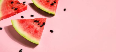 Slices of tasty watermelon on pink background with space for text