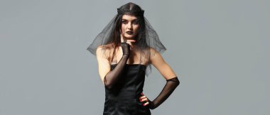 Gri arka planda Cadılar Bayramı için giyinmiş güzel kadın