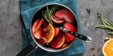 Pot of delicious mulled wine on grey table, top view