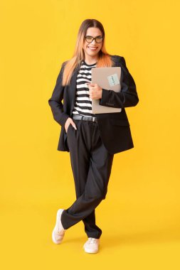 Transgender programmer with laptop on yellow background clipart