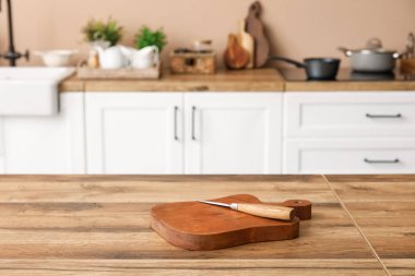 Cutting board with knife on table in kitchen