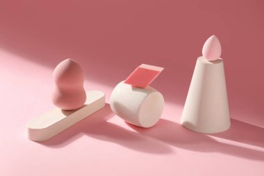 Makeup sponges with decor on pink background