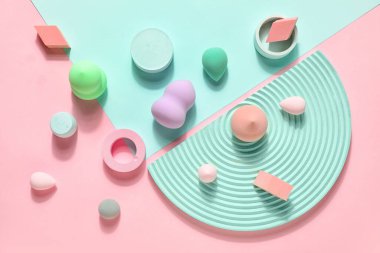 Makeup sponges with decor on pink and blue background