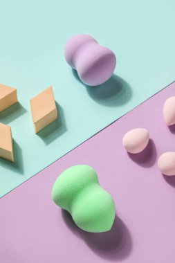 Makeup sponges on blue and violet background