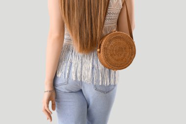 Açık arkaplanda çantalı bir kadın.