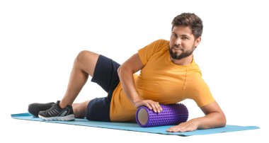 Young man training with foam roller on white background