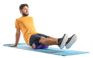 Young man training with foam roller on white background