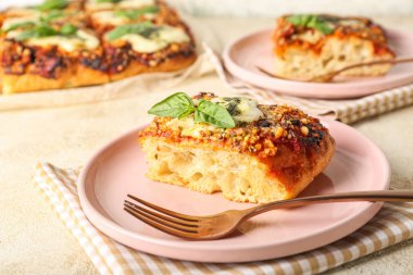 Plate of tasty Italian pie with mozzarella and pesto sauce on light background, closeup