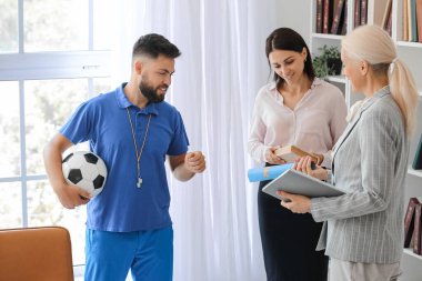 Teachers with world map in school office