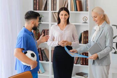Teachers with world map in school office