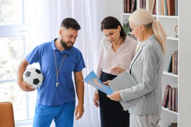 Teachers with world map in school office