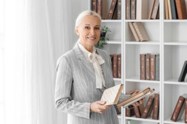 Mature teacher with books in school