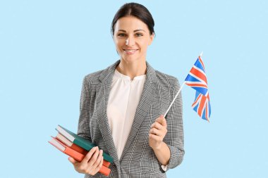 Female English teacher with UK flag ad books on blue background