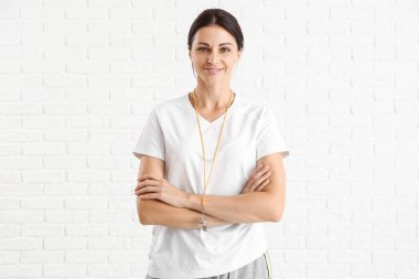 Beautiful PE teacher on white brick background