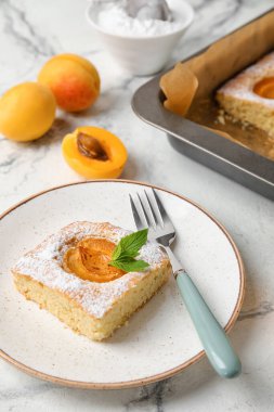 Plate with delicious apricot pie on light background, closeup