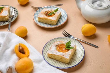 Plates with pieces of delicious apricot pie on color background