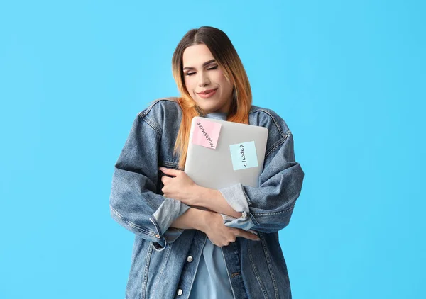 Transgender programmer with laptop on blue background