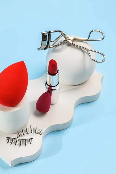 Makeup Sponge Curler Lipstick False Eyelashes Decor Blue Background — Zdjęcie stockowe
